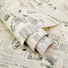 an old newspaper is laying on top of some papers that have been rolled up and stacked together