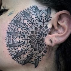 a woman's face with a tattoo on her neck and behind it is a circular design