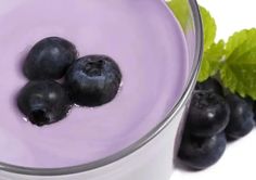 three blueberries in a glass next to some leaves