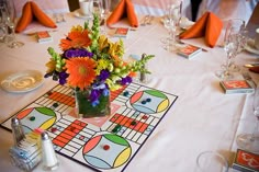 the table is set with colorful flowers and place cards