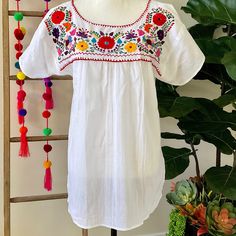 "This traditional Mexican blouse is beautifully made in Merida Yucatan, Mexico, each piece is individually hand made and hand embroidered.  You will love this lightweight blouse made of organic cotton, this natural material gives the blouse a delicate and relaxed feel.   Details: Size M-L measurements: Bust: 42\" - 29\" length(shoulder to bottom Hem) Cotton  thread Embroidered Material: 100% Cotton All items are shipped from the US All Mi Mundo Mexicano  items are 100% handmade by artisans in Mexico. Each stitch and item is completely unique and one-of-a-kind, so you'll never find two that are exactly the same! All  items may vary slightly in size, color, and design - that's what makes handmade items so special and charming!  Your Purchase supports artisans craft and families" White Bohemian Peasant Top With Chikankari Embroidery, Peasant Floral Embroidered Top For Beach, Traditional White Top With Intricate Embroidery, Bohemian Peasant Top With Floral Embroidery, Embroidered Bohemian Blouse For Traditional Ceremonies, Traditional White Embroidered Top, White Cotton Peasant Top With Embroidered Neckline, White Bohemian Peasant Top With Intricate Embroidery, White Bohemian Top With Intricate Embroidery