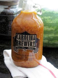 a bottle of carolina brewery sitting on top of a white towel next to watermelon