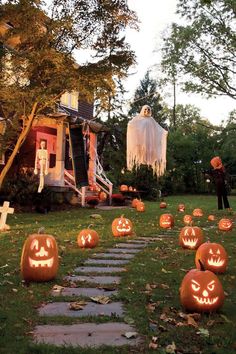 halloween pumpkins with faces carved into them in front of a house