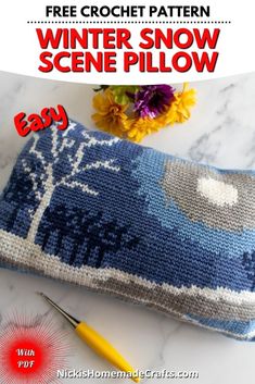 a knitted pillow sitting on top of a table next to a crochet needle