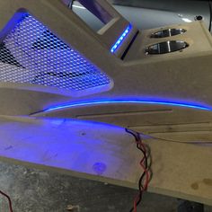 the inside of a vehicle with blue lights on it and wires attached to the side