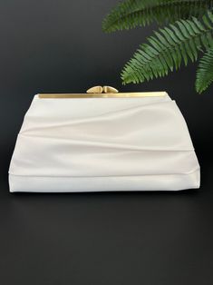 "This pleated wedding clutch is a timeless and elegant accessory that can add a touch of sophistication to any wedding outfit. This clutch is perfect for brides, bridesmaids, or wedding guests who want to make a statement with their accessories. The pleated design adds texture to the clutch, making it a standout piece that adds classic elegance to any outfit. Available in various colors. This clutch is spacious enough to store essential items like a phone, makeup, and other small accessories.  B Elegant Pearl Handle Evening Bag For Wedding Guest, Elegant Satin Rectangular Evening Bag, Elegant Rectangular Satin Evening Bag, Elegant Beige Clutch For Wedding Guest, Elegant White Bridal Accessories For Wedding, Chic Wedding Clutch With Pearl Handle, Elegant Cream Clutch For Wedding Guest, Classic White Bridal Accessories For Formal Occasion, Elegant White Clutch For Events