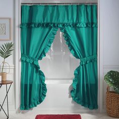 a bathroom with green curtains and a red rug in front of the shower curtain that is open