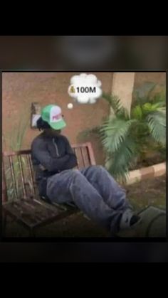 a man sitting on a bench with his feet up in the air and wearing a green hat