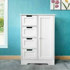 a white cabinet with drawers against a blue wall