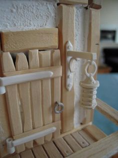 a wooden toy house made out of wood and plastic material with doors, windows, and handles