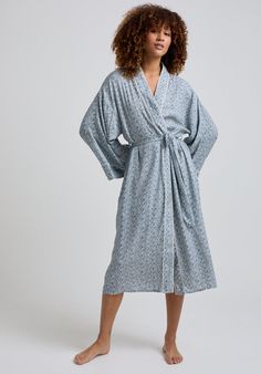 The charming Corina robe is cut from our inimitable cotton and adorned with an interesting blue Ditsy floral print. This oversized kimono-inspired robe boasts fluted sleeves and a detachable belt, creating a flattering silhouette. Contrast piping on the cuff and neck, complete this effortlessly feminine piece.    Cool machine wash only. Wash inside out and with similar colours 100% Cotton Modal   Cool machine wash only. Wash inside out and with similar colours Blue Spring Robe For Loungewear, Spring Cotton Robe With Floral Print, Cotton Floral Print Robe For Daywear, Blue Summer Robe For Daywear, Blue Long Sleeve Robe For Spring, Blue Robe For Spring Daywear, Blue Robe For Summer Daywear, Long Sleeve Blue Robe For Spring, Blue Kimono With Kimono Sleeves For Daywear