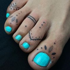 a person with blue toenails and tattoos on their feet