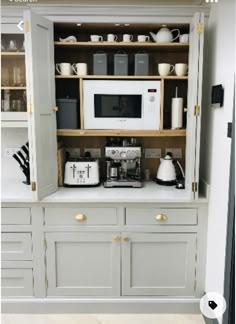 a kitchen with gray cabinets and white appliances on the counter top, along with coffee maker and toaster