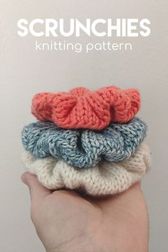 a hand holding three knitted scrunches on top of each other in different colors