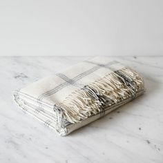 a white and black plaid blanket laying on top of a marble counter