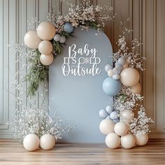 a baby it's cold outside backdrop with balloons and greenery on the wall