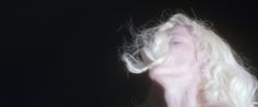 a woman with blonde hair blowing in the wind