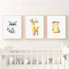 three watercolor animals are hanging on the wall next to a baby's crib