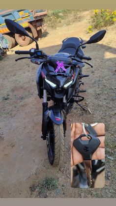 a black motorcycle parked on top of a dirt field