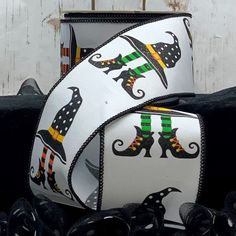 two pieces of white ribbon with black and green witches on them, sitting next to each other