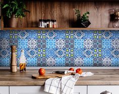 a kitchen counter with an orange and blue tiled backsplash