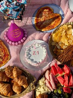 a table topped with lots of different types of food next to a cake and other desserts