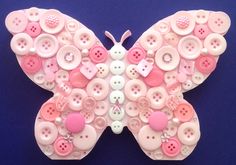 a butterfly made out of buttons on a blue background with pink and white accents,