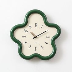 a green and white clock with numbers on the face is shown against a white background