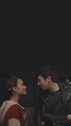 a man and woman standing next to each other in front of a black background with the words, i love you written on it