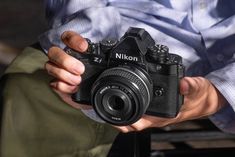 a man holding a camera in his hands with the lens pointed up to the camera