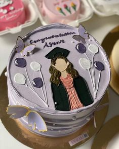 a cake decorated with an image of a woman wearing a graduation cap on top of it