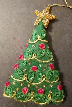 a green christmas tree ornament hanging from a gold chain