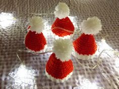 four knitted santa hats sitting on top of a table