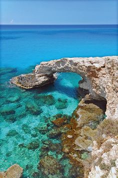 the water is crystal blue and clear with an arched rock bridge over it's surface