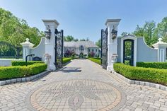 the driveway is lined with hedges and stone walkways