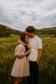 a man and woman standing together in a field