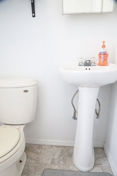 a white toilet sitting next to a sink in a bathroom