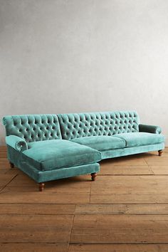 a blue couch sitting on top of a wooden floor