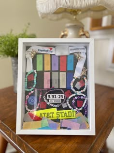 a wooden table topped with a white frame filled with assorted items