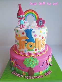 a colorful birthday cake decorated with the number six and an image of a gnome on top