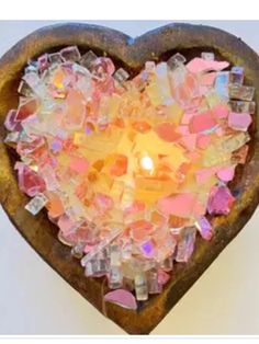 a heart - shaped candle holder filled with glass shards