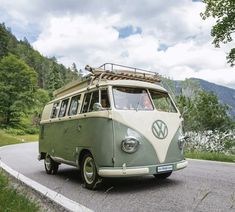 an old vw bus is driving down the road