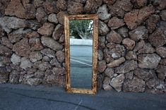 a mirror sitting on the side of a stone wall