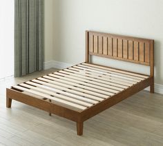 a bed with wooden slats is shown in an empty room next to a window