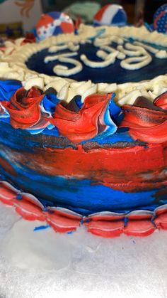 a cake with red, white and blue frosting on it sitting on a table