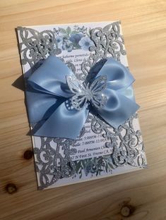 a close up of a card with a bow on the front and blue ribbon on the back