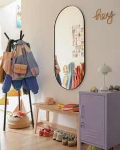 there is a mirror and some shoes on the floor next to a table with a bag