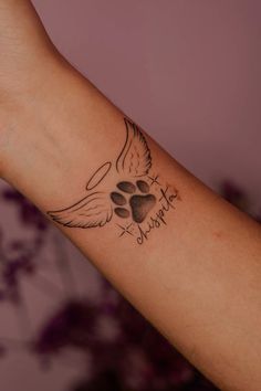 a tattoo on the arm of a woman with a dog's paw and heart