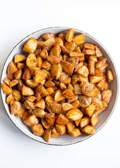 a bowl filled with cooked potatoes on top of a white table