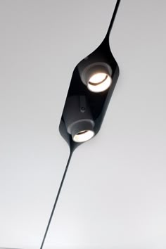 two lights that are on the side of a ceiling light in a room with white walls and flooring